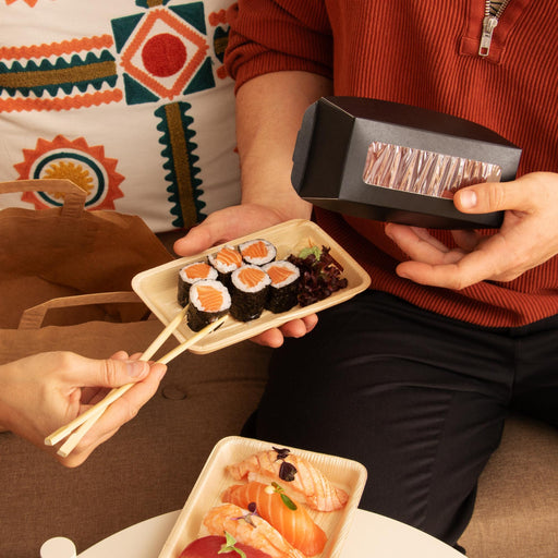 Take-Away-Box mit frischem Sushi auf einem Tisch